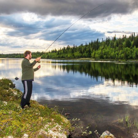 Bilde av mann som fisker i fjellvann