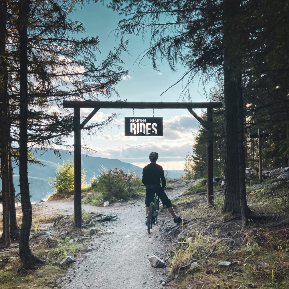 Bilde av mann under sykkelportal i Nesbyen, "Nesbyen Rides"